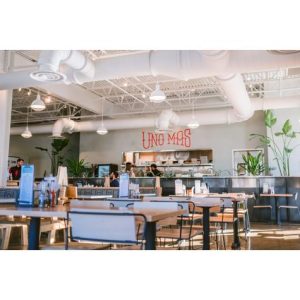 A bright and airy restaurant interior with pendant lights and neon signage