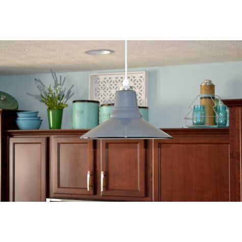 A grey pendant light hangs above wooden kitchen cabinets