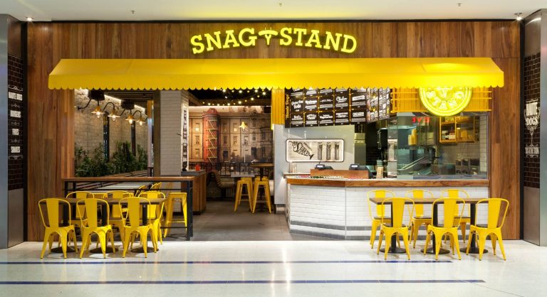 A bright yellow and wood-panelled fast-food restaurant interior with seating