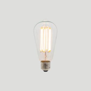 A clear glass Edison-style LED filament light bulb is shown against a neutral grey background