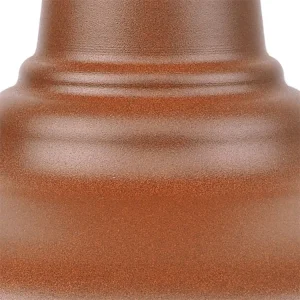 A close-up shot of a textured, bronze-coloured light fixture