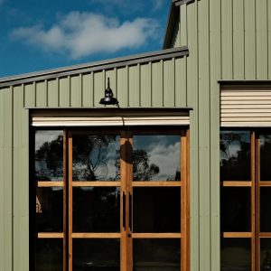 30cm Sydney caged gooseneck barn light in Black Ace, close-up above shed doors