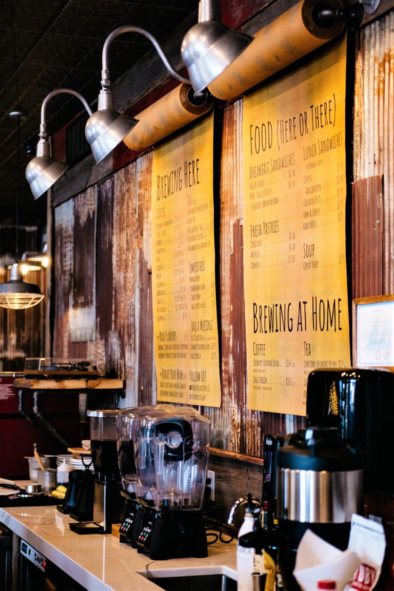 Industrial-style gooseneck lights illuminate menus in a rustic coffee shop