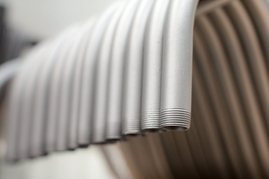 A row of silver threaded pipes are shown in close-up