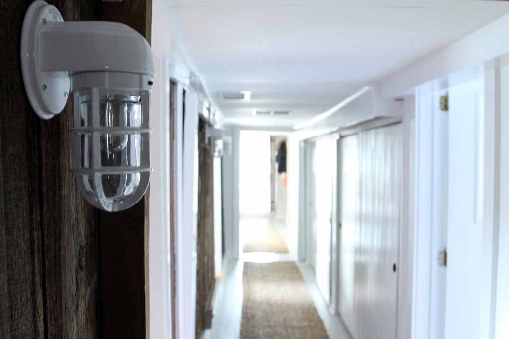 Long hallway featuring Streamline Atomic Sconces with opposing sides consisting of a whitewashed wall with wood to accent the space.