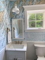bathroom with worldmap wallpaper showing white wall light over sink