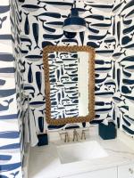 Blue powder room with nautical wallpaper showing blue wall light