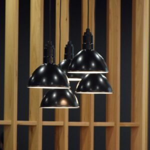 A cluster of four black pendant lights hang in front of a wooden slatted screen