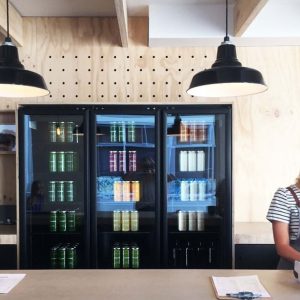 Three black pendant lights hang above a counter in a modern cafe